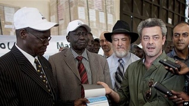Eamon Omordha, right, Deputy Director of United Nations Integrated Referendum and Electoral Division, hands over a referendum ballot to Justice Chan Reec Madut, left, Chairman of the Southern Sudan Referendum Bureau, during a material handover ceremony in