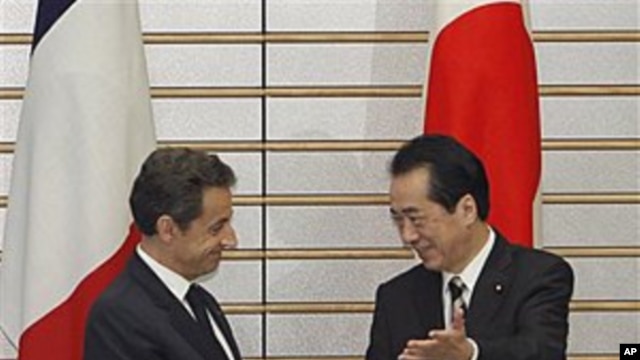 French President Nicolas Sarkozy is welcomed by Japanese Prime Minister Naoto Kan prior to their talks at Kan's official residence in Tokyo, March 31, 2011
