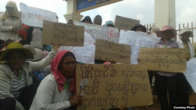 រូបឯកសារ៖ បាតុករជាអ្នកភូមិដែលកំពុងស្វែងរកដំណោះស្រាយក្នុងជម្លោះដីធ្លី កាន់បដាតវ៉ាអំឡុងពេលមកដាក់ញ្ញត្តិសុំអន្តរាគមន៍នៅមុខសាលាស្រុកស្រែអំបិល កាលពីថ្ងៃសុក្រ ទី២៥ ខែមីនា ឆ្នាំ២០១៦។ (រូបថតផ្ដល់ឱ្យដោយអង្គការលីកាដូ)