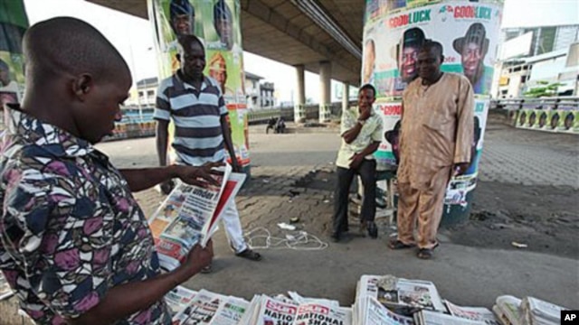 Unidentified man reads newspaper with headline 'National Shame' after election was postponed Saturday by Election Commission, Lagos, Nigeria, April 3, 2011