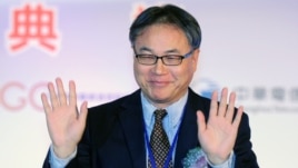 China Mobile Chief Executive Li Yue waves to the press during a ceremony in Taipei linking the first undersea fiber optic cable between Taiwan and China on January 18, 2013.  