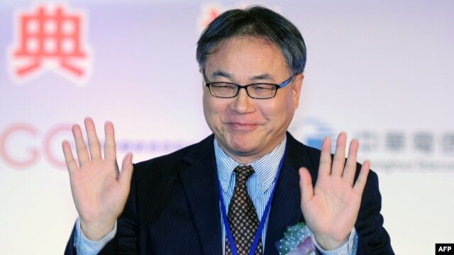 China Mobile Chief Executive Li Yue waves to the press during a ceremony in Taipei linking the first undersea fiber optic cable between Taiwan and China on January 18, 2013.  
