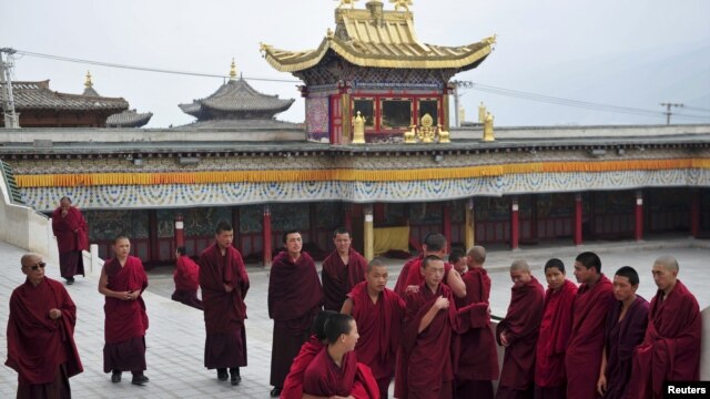Tibetan monks prepare to attend a prayer meeting for tourists at a temple in Huangnan Tibetan Autonomous Prefecture, Qinghai province, China, July 19, 2012.