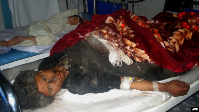 Injured Afghan villagers lie on beds in a hospital ward in Farah Province after they were caught in an explosion of a roadside bomb, November 16, 2012.