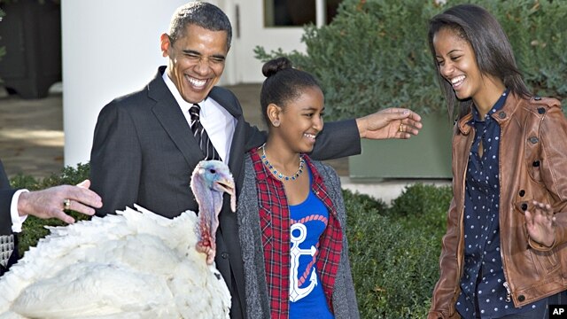 President Barack Obama, with daughters Sasha (l) and Malia carries on the Thanksgiving tradition of saving a turkey from the dinner table with a "presidential pardon," Nov. 21, 2012, in the Rose Garden of the White House.