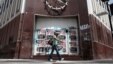 FILE - A woman walks in front of a closed bank in the neighborhood of Rio Piedras in San Juan, Puerto Rico, June 29, 2015. 