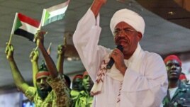 Supporters wave flags as Sudanese President Omar al-Bashir addresses a rally in Khartoum, Sudan, April 18, 2012.