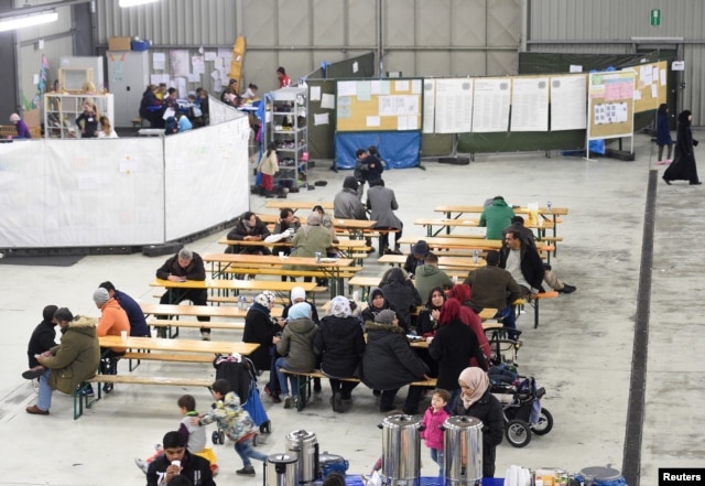 Migrants sit in a canteen in a refugee camp in Celle, Lower-Saxony, Germany, Oct. 15, 2015.