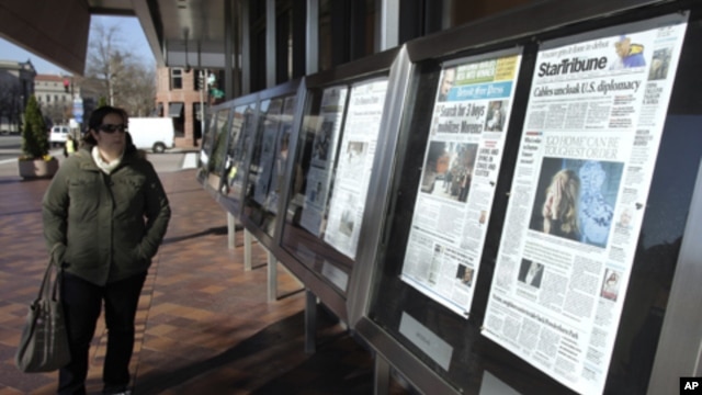 A woman reads the front pages of U.S. newspapers outside the Newseum in Washington.