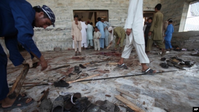 Pakistani villagers clean the floor of a mosque targeted by a suicide attacker in the Pakistani tribal area of Khyber, Aug. 19, 2011.