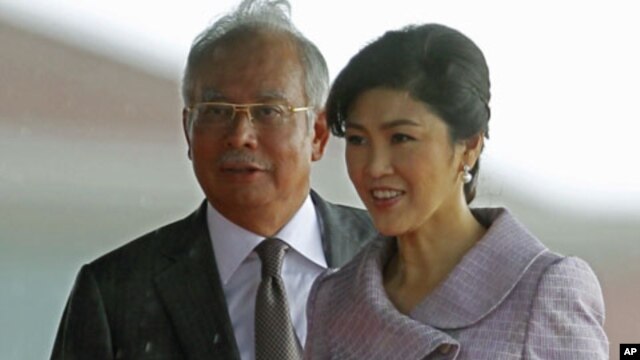 Visiting Thailand's Prime Minister Yingluck Shinawatra and her Malaysian counterpart Najib Razak walk to step down from the stage after the welcoming ceremony outside Razak's office in Putrajaya near Kuala Lumpur, February 20, 2012.