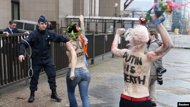 Femen members protest Putin's human rights record, European Union Council building, Brussels, Dec. 21, 2012.
