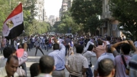 Protesters try to stop the stone throwing after scuffles broke out between groups of several hundred protesters in Tahrir square when chants against the new Islamist president angered some in the crowd in Cairo, Egypt, October 12, 2012.