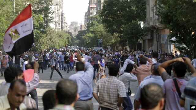 Protesters try to stop the stone throwing after scuffles broke out between groups of several hundred protesters in Tahrir square when chants against the new Islamist president angered some in the crowd in Cairo, Egypt, October 12, 2012.