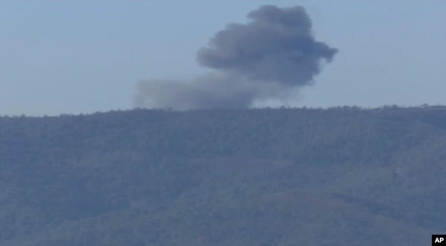 This frame grab from video by Haberturk TV, shows smoke from a Russian warplane after crashing on a hill as seen from Hatay province, Turkey, Nov. 24, 2015.