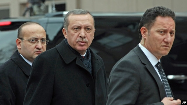 Turkish Prime Minister Recep Tayyip Erdogan, center, is flanked by his advisor Yalcin Akdogan, left, and a security official as he arrives at his office in Ankara, January 30, 2013.