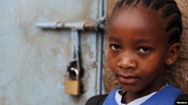 A girl stands next to her locked classroom as a nationwide strike by Kenyan teachers demanding a salary increase left most learning institution paralyzed, in Nairobi, September 5, 2012. 