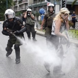A policeman sprays tear gas as a protester walks away during an anti-austerity rally in Athens June 29, 2011.
