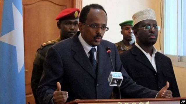 Somali PM Mohamed Abdullahi Mohamed, left, announces his resignation during a news conference, alongside Somali President Sharif Sheik Ahmed, right, at the presidential palace in Mogadishu, Somalia (File Photo -, June 19, 2011)