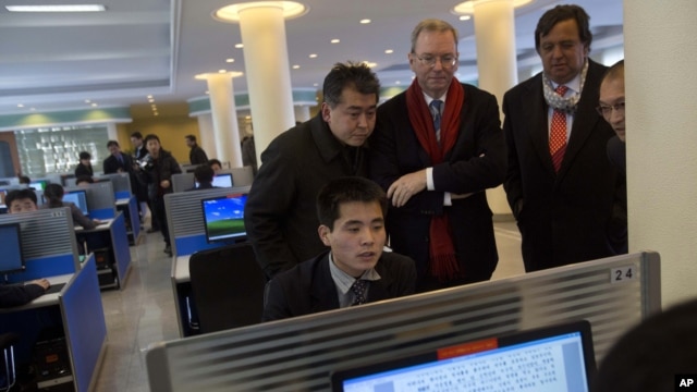 Executive Chairman of Google, Eric Schmidt (C) and former New Mexico governor Bill Richardson (2nd R) watch as a North Korean student surfs the Internet at a computer lab during a tour of Kim Il Sung University in Pyongyang, January 8, 2013. 
