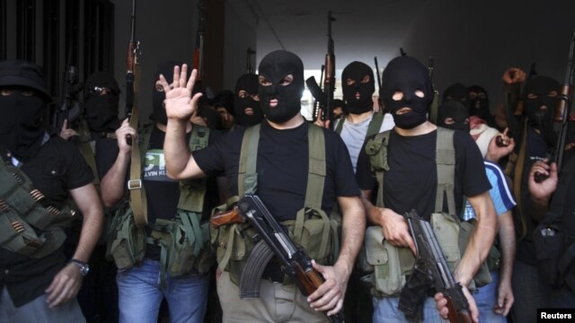 Shi'ite masked gunmen from the Mekdad clan gather at the Mekdad family's association headquarters in the southern suburbs in Beirut, Lebanon, August 15, 2012.