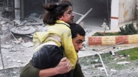 Syrian man carries his sister who was wounded in a government airstrike hit the neighborhood of Ansari, in Aleppo, Syria, Sunday, Feb. 3, 2013.