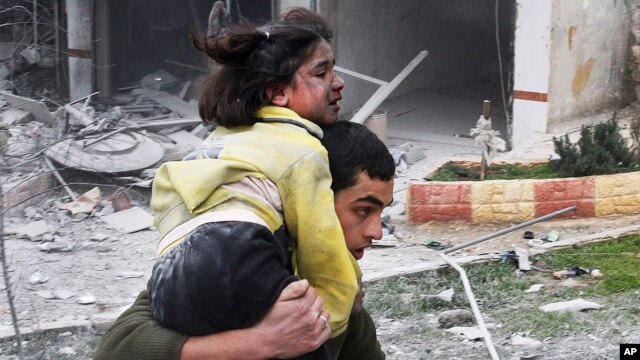 Một thanh niên Syria khiêng người em gái bị thương trong vụ không kích của chính phủ vào khu phố Ansari, ở Aleppo, ngày 3/2/2013.
