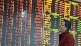 An investor looks at an electronic board showing stock information at a brokerage house in Hangzhou, Zhejiang province, China, December 14, 2012. 