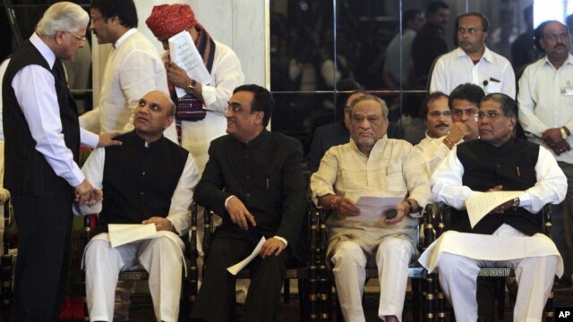 Ashwini Kumar, left, a junior minister, greets Pallam Raju, who moved from Defense to Human Resources Development ministry at the swearing-in ceremony, New Delhi, India, October 28, 2012.