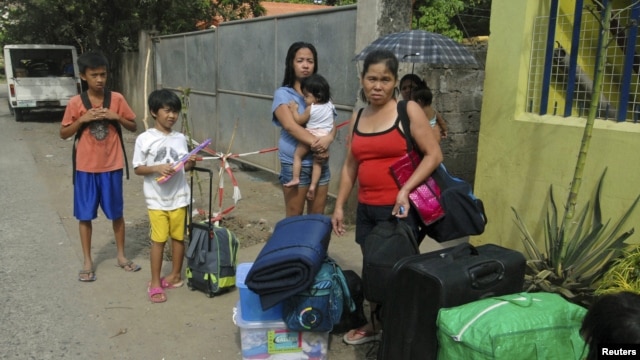 Residents wait for a truck to transport them into an evacuation center as local officials ordered enforced evacuation ahead of Typhoon Bopha in Cagayan de Oro City, southern Philippines, December 3, 2012.