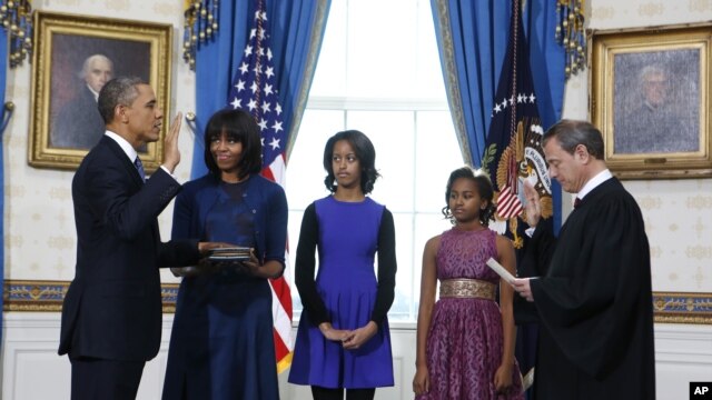 President Barack Obama is officially sworn-in by Chief Justice John Roberts in the Blue Room of the White House during the 57th Presidential Inauguration in Washington, D.C., January 20, 2013. Next to Obama are first lady Michelle Obama, holding the Robin