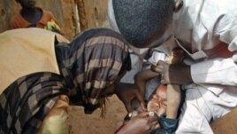 Des volontaires vaccinant un enfant à Kaduna, au Nigeria.
