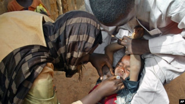 Volunteers administer a polio vaccine to a child in Kaduna, Nigeria.