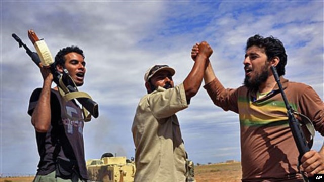 Libyan revolutionary fighters react during an attack on the city of Sirte, Libya, October 6, 2011.