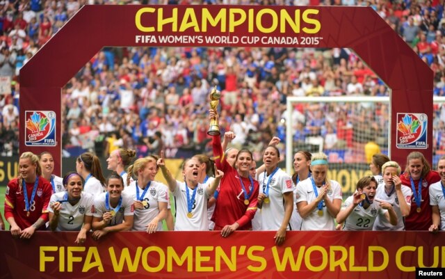 United States goalkeeper Hope Solo (1) hoists the FIFA Women's World Cup trophy as she and her teammates pose with their medals after defeating Japan in the final of the FIFA 2015 Women's World Cup at BC Place Stadium, July 5, 2015.