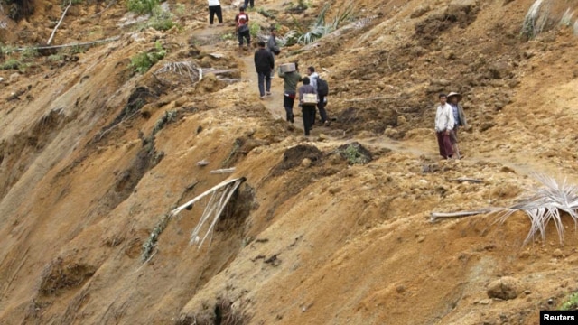 Warga berjalan di jalan setapak di wilayah yang terkena bencana tanah longor di Koto Timur,Padang Pariaman (Foto: dok). Dua buah insiden tanah longsor dilaporkan terjadi di wilayah Sumatera, menewaskan sedikitnya sembilan orang dan 17 orang dinyatakan hilang (26/1).