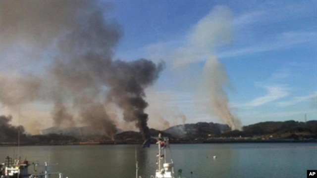 This picture taken by a South Korean tourist shows huge plumes of smoke rising from Yeonpyeong island in the disputed waters of the Yellow Sea on November 23, 2010. North Korea fired dozens of artillery shells onto a South Korean island, setting of an exc