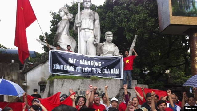 Protesters chant anti-China slogans while standing at a war martyrs monument during an anti-China protest in Hanoi, July 1, 2012.