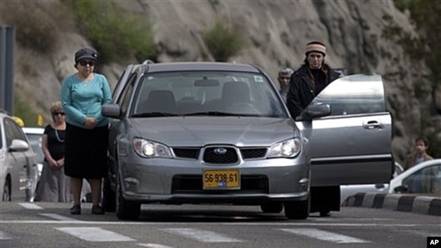 Israelis stand still beside their cars on highway as two-minute siren sounds in memory of Holocaust victims, Jerusalem, April 19, 2012.