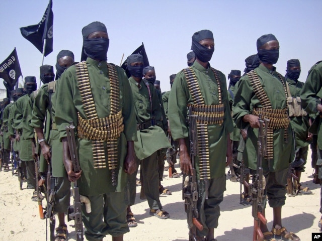 FILE - A February 2011 photo shows al-Shabab fighters on parade with their guns during military exercises on the outskirts of Mogadishu,Somalia.