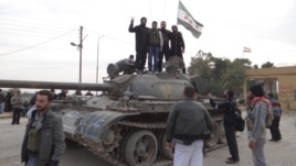 Free Syrian Army fighters pose on a tank after they said they fought and defeated government troops from the town of Ras al-Ain, near the province of Hasaka, 600 kilometers from Damascus, November 22, 2012.