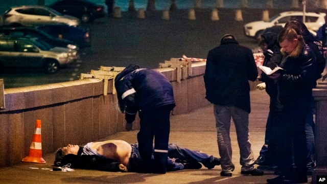 Russian police look at the the body of Boris Nemtsov, a former Russian deputy prime minister and opposition leader near the Kremlin in Moscow, Feb. 28, 2015.