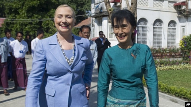 Burma's pro-democracy opposition leader Aung San Suu Kyi, right, and U.S. Secretary of State Hillary Rodham Clinton tour the grounds after meetings at Suu Kyi's residence in Rangoon, Burma December 2, 2011.