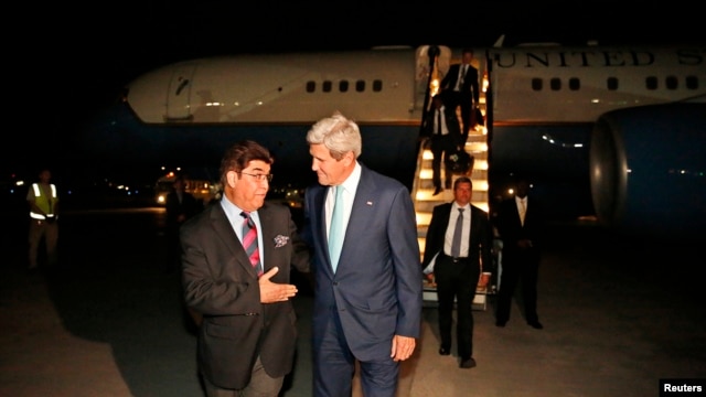 U.S. Secretary of State John Kerry talks with Afghanistan's Ministry of Foreign Affairs chief of protocol Ambassador Hamid Siddiq (L) as Kerry arrives at Kabul International airport in Kabul, July 11, 2014.
