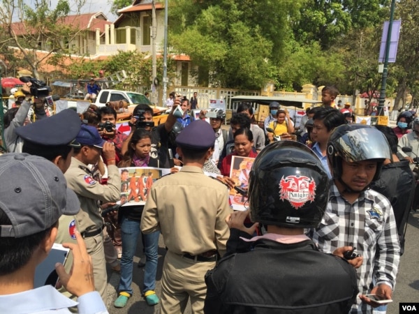 មន្ត្រី​ប៉ូលីស​រារាំង​ក្រុម​គ្រួសារ​របស់​សកម្មជន​បរិស្ថាន​បី​នាក់​នៃ​ចលនា​មាតា​ធម្មជាតិ​មិន​ឲ្យ​ធ្វើ​ដំណើរ​លើ​មហាវិថី​ព្រះ​នរោត្តម​ ទៅ​កាន់​ផ្ទះ​លោក​នាយករដ្ឋមន្ត្រី​ ហ៊ុន សែន។​ (ហ៊ុល​ រស្មី/VOA)