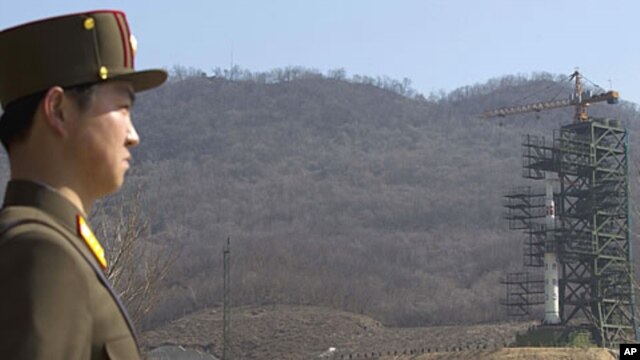 A crowd of media gather around a North Korean official in front of North Korea's Unha-3 rocket, slated for liftoff between April 12-16, at Sohae Satellite Station in Tongchang-ri, North Korea, April 8, 2012.