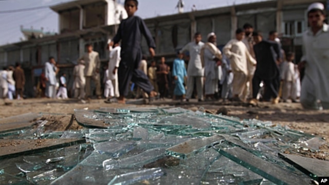 Afghans walk pass the derbies at the site of a bomb explosion in Laghman province east of Kabul, Afghanistanm, June 11, 2011.