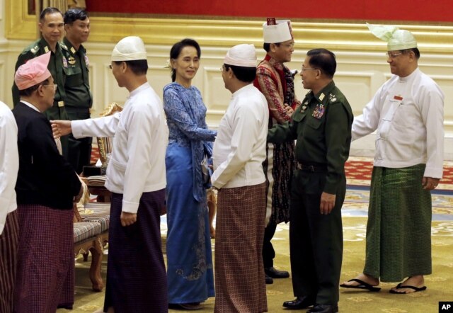 Aung San Suu Kyi, center, shakes hands with Senior General Min Aung Hlaing after the presidential handover ceremony in Naypyitaw, Myanmar, Wednesday, March 30, 2016.