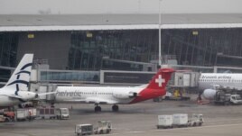 Baggage carts make their way past a Helvetic Airways aircraft from which millions' of dollars worth of diamonds were stolen on the tarmac of Brussels international airport, February 19, 2013.