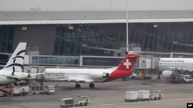 Baggage carts make their way past a Helvetic Airways aircraft from which millions' of dollars worth of diamonds were stolen on the tarmac of Brussels international airport, February 19, 2013.